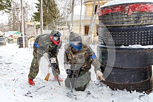 Cool paintball in winter. Two shooters behind fortifications.