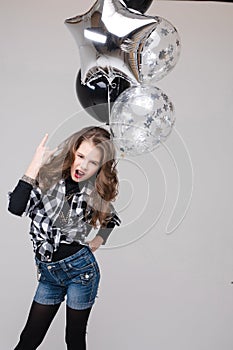 Cool pre-teen girl with rock sign. She is showing rock n roll or horn sign, gesturing at camera and pouting her lips