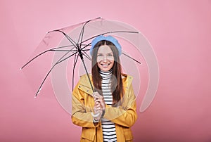 Cool pretty girl in yellow rain jacket with umbrella