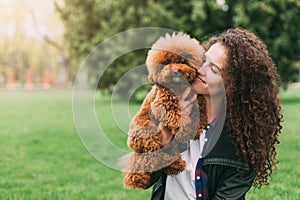 Cool puppy and young woman having fun in park