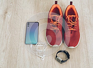 Cool runner sneakers with smartphone, earphones and fitbit sport watch. Ready for training, healthy life