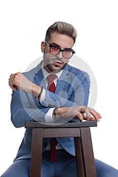 Cool seated businessman folding his arms and resting them