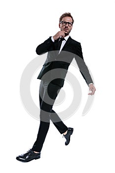 Cool standing man in black suit touching chin