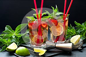 Cool strawberry mojito  cocktail in glasses on  dark table