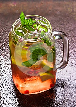 Cool summer cocktail with ice cube, lime, mint leaves, fresh pomegranate juice and pomegranate seeds