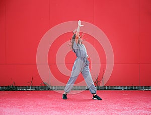 Cool teen girl dancing on red background. Fiery hip hop dancer performance. Contemporary dance school advertising
