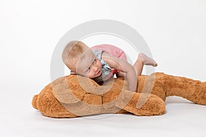 Cool toddler girl is lying on a big plush toy
