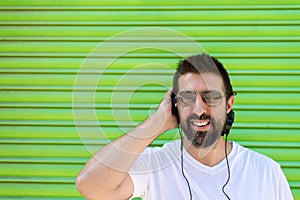 Cool trendy funny beard man in headphones listening music on colored background