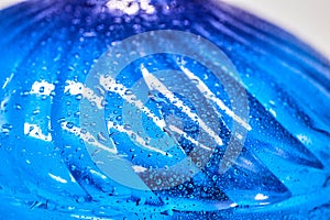 Cool water and water drops on a blue plastic bottle . Selective focus.