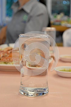 Cool water glass with ice on table