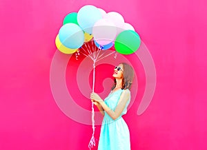 Cool woman is looking on an air colorful balloons having fun