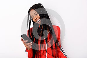 Cool young african american woman listening music with headphone and mobile phone
