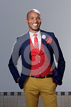 Cool young african man in fashionable suit smiling outdoors