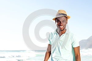 Cool young african man with hat at the beach