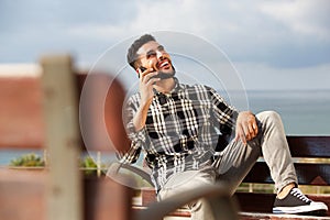 Cool young arabic man talking on mobile phone outdoors