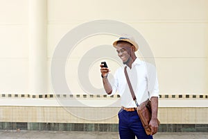 Cool young black man looking at mobile phone