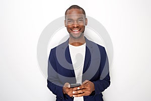 Cool young black man smiling with mobile phone against white background