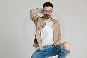 Cool young casual model holding hand behind neck