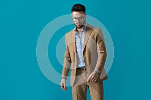 Cool young fashion man with glasses looking down and posing