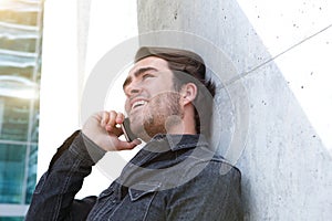 Cool young man calling by mobile phone outside