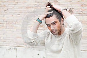 Cool young man fashion model, hairstyle. Hand in the hair