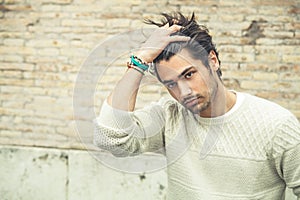 Cool young man fashion model, hairstyle. Hand in the hair