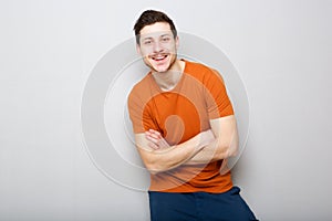 Cool young man smiling against gray background