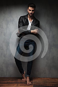 Cool young man standing with hands crossed and bare feet