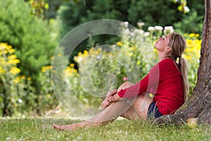 Cool young woman enjoying summer freshness under a tree photo