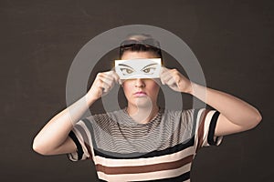 Cool youngster looking with a paper hand drawn eyes