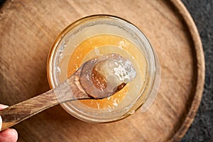 Cooled congealed beef bone broth on a wooden spoon