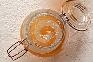 Cooled down congealed beef bone broth in a glass jar on a bright background  top view