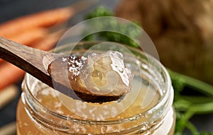 Cooled jellied beef bone broth on a spoon