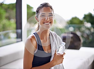 Cooling down with mineral goodness. Portrait of an attractive young woman relaxing after a workout.