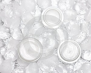 Cooling effect moisturizing creams surrounded by ice cubes, top