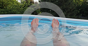 Cooling off in water inflatable pool in summer