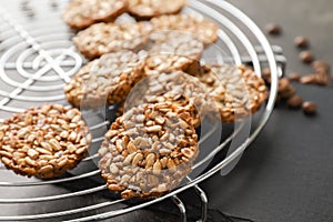 Cooling rack with tasty brittles on table, closeup