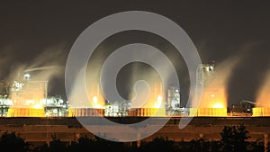 Cooling tower of oil refinery industrial plant at night, Thailand