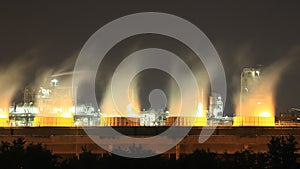 Cooling tower of oil refinery industrial plant at night, Thailand