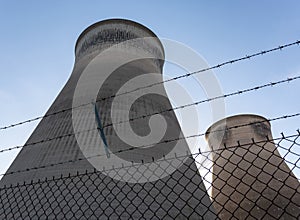 Cooling towers behind barbed wire fence