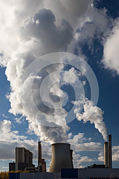 Steam clouds towering over the cooling towers and chimneys of a brown coal power plant in Germany