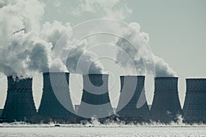 Cooling towers of NPP or Nuclear Power Plant with thick smoke. Dark toned image.