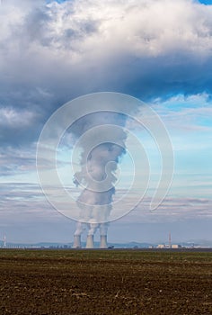 Chladicí věže jaderné elektrárny Jaslovské Bohunice EBO na Slovensku. Mraky hustého kouře z komínů na modré obloze