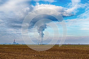 Chladiace veže jadrovej elektrárne Jaslovské Bohunice EBO na Slovensku. Mraky hustého dymu z komínov na modrej oblohe