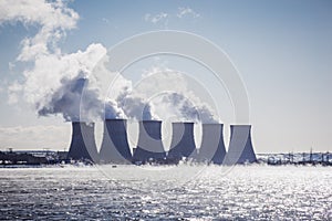 Cooling towers of a Nuclear Power Plant or NPP with thick smoke on blue sky