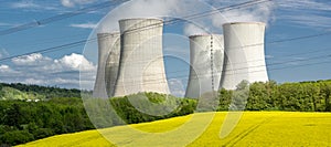 Cooling towers of nuclear power plant with the yellow field of rapeseed, canola or colza. Mochovce. Slovakia