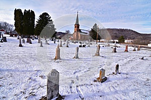 Coon valley cemetery in Winter with the 1876 evangelical Norwegian Lutheran church and drifters area bluffs covered in snow.