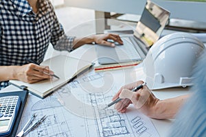 Cooperation Corporate designers in the office are working on a new project Planning blueprint Design at construction site at desk