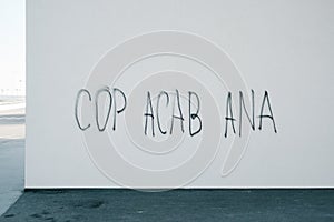 Cop acab ana graffitti lettering on a urban wall. Meaning is- all cops are bastards. Criminal violation and revolution concept photo