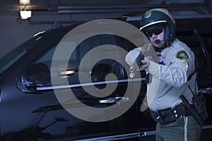 Cop Aiming Rifle While Standing Against Car